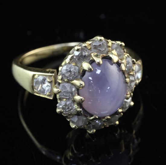 A gold, star sapphire and diamond oval cluster ring, size K.